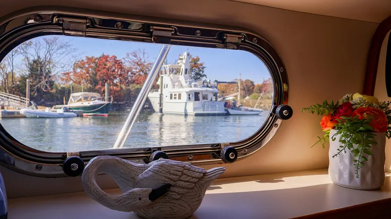 Slide: The Image of View from Fortier 33 boat window, showcasing docked boats and autumn scenery, 2008 model. - 21