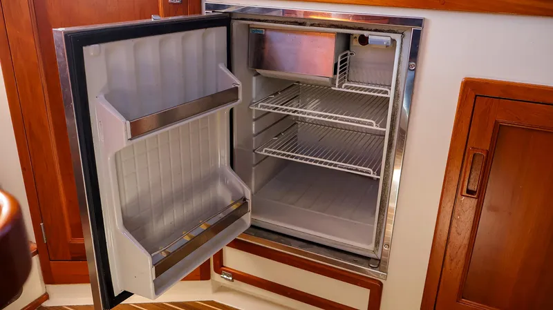 Slide: The Image of Open refrigerator inside 2008 Fortier 33 boat, showcasing interior shelves and door storage. - 23