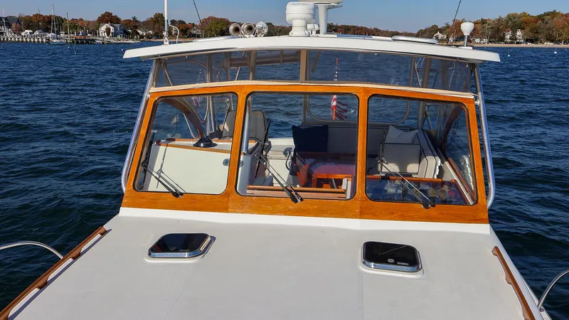 Slide: The Image of 2008 Fortier 33 boat on water, featuring a wooden cabin and clear windows. - 5