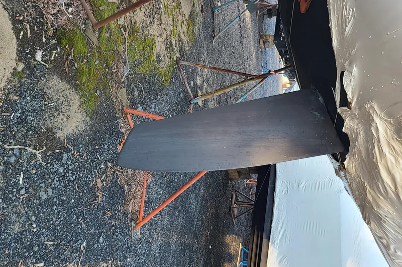 Slide: The Image of Keel of a 2007 Alerion Express 28 sailboat on a gravel surface. - 11