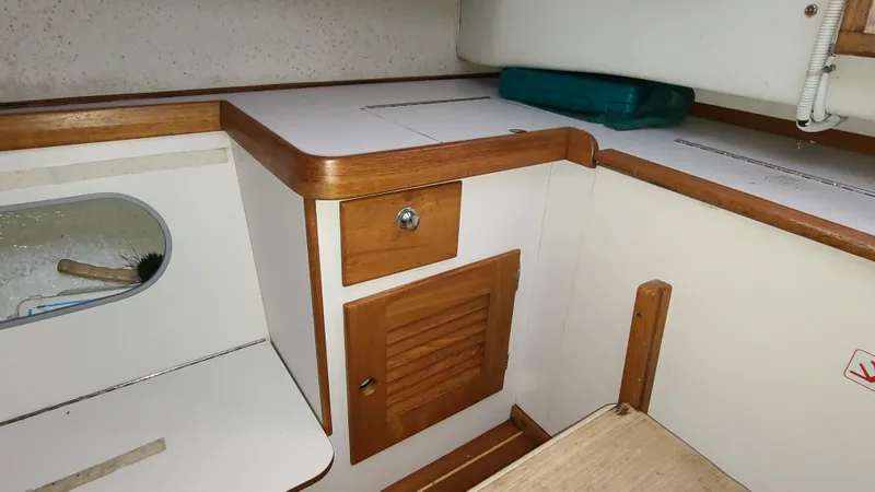 Slide: The Image of Interior of 2007 Alerion Express 28 sailboat with wooden cabinetry and storage compartments. - 15