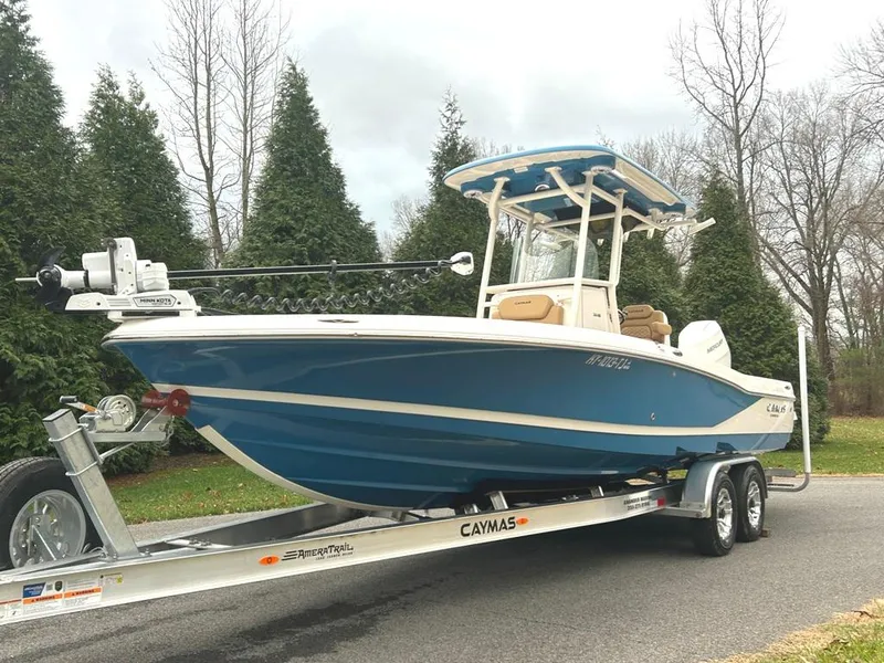 Slide: The Image of 2025 Caymas 26 HB boat on trailer, blue hull, parked outdoors. - 0