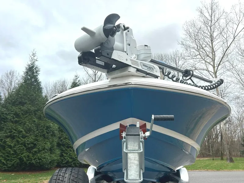 Slide: The Image of 2025 Caymas 26 HB boat with trolling motor, parked outdoors. - 1