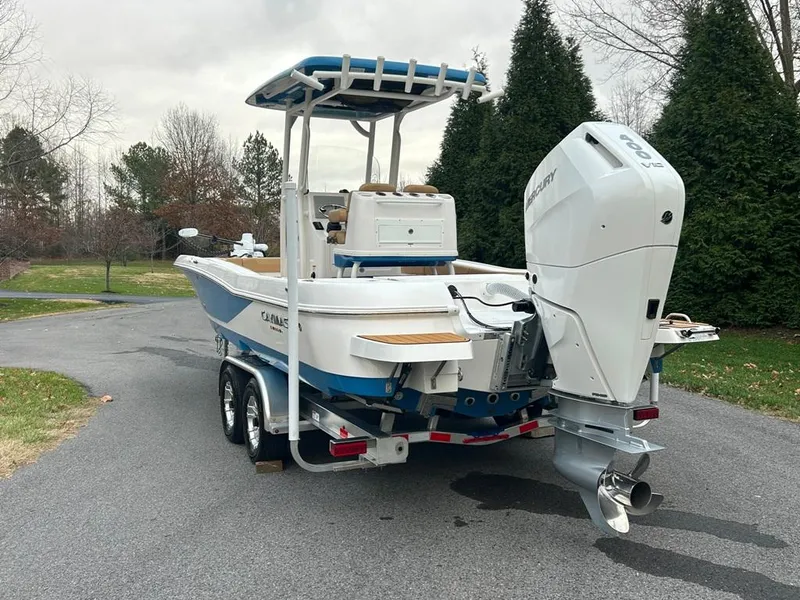Slide: The Image of 2025 Caymas 26 HB boat on trailer with outboard motor in a driveway. - 15