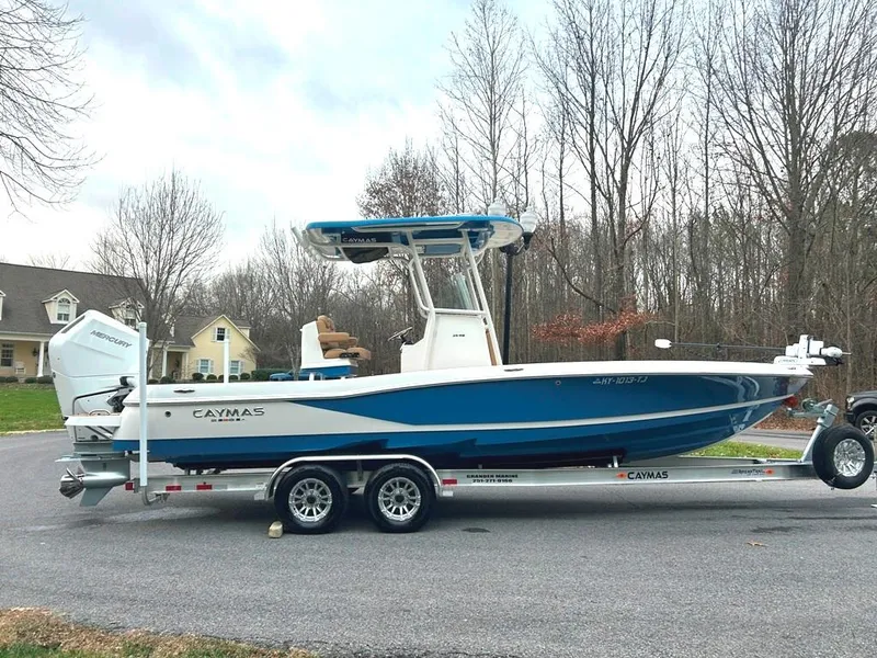 Slide: The Image of 2025 Caymas 26 HB boat on trailer, parked in residential area. - 18