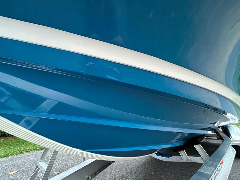 Slide: The Image of 2025 Caymas 26 HB boat hull in vibrant blue on trailer. - 20