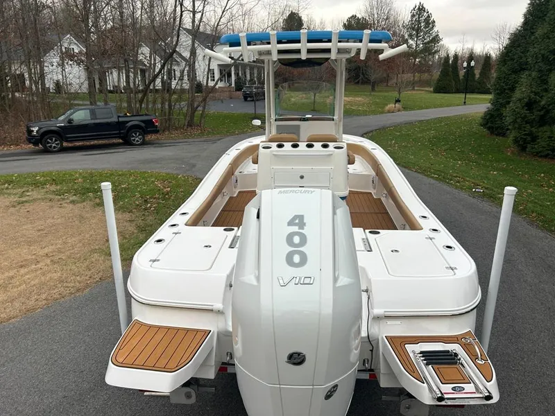 Slide: The Image of 2025 Caymas 26 HB boat with powerful 400 V10 engine, parked on a driveway. - 23
