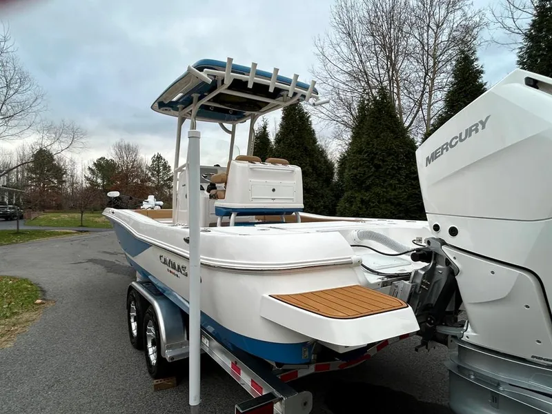 Slide: The Image of 2025 Caymas 26 HB boat on trailer with Mercury engine, parked outdoors. - 25