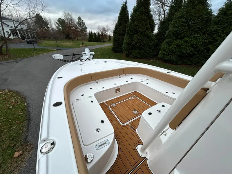 Slide: The Image of 2025 Caymas 26 HB boat with spacious deck and seating, parked near trees. - 27