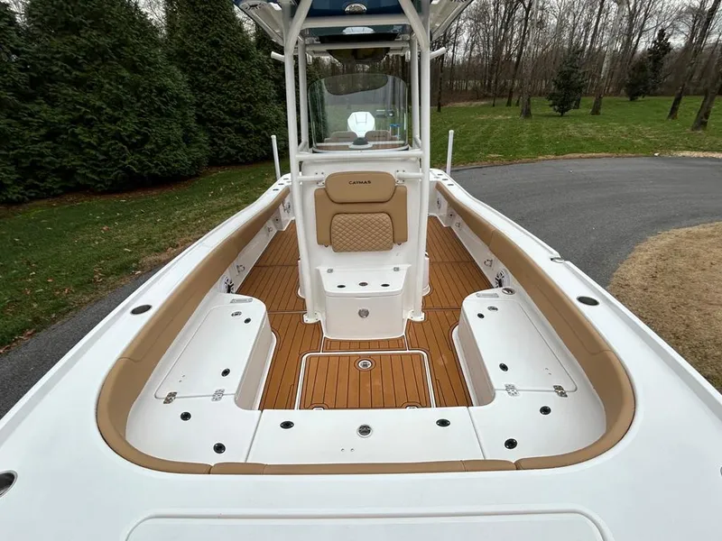 Slide: The Image of 2025 Caymas 26 HB boat with spacious deck and seating, surrounded by greenery. - 29