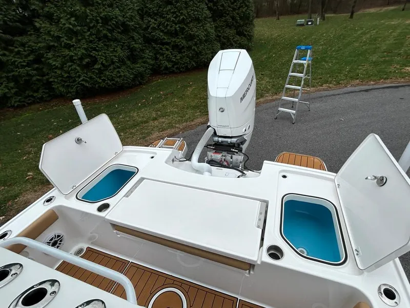 Slide: The Image of 2025 Caymas 26 HB boat with open storage compartments and outboard motor. - 37