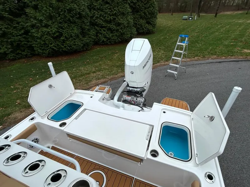 Slide: The Image of 2025 Caymas 26 HB boat with open storage compartments and outboard motor. - 38