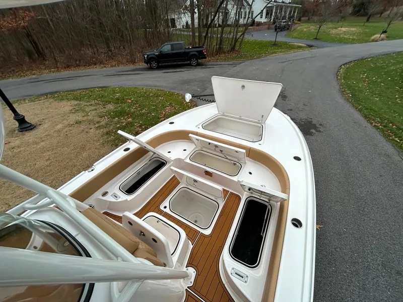 Slide: The Image of 2025 Caymas 26 HB boat with open storage compartments on a driveway. - 41