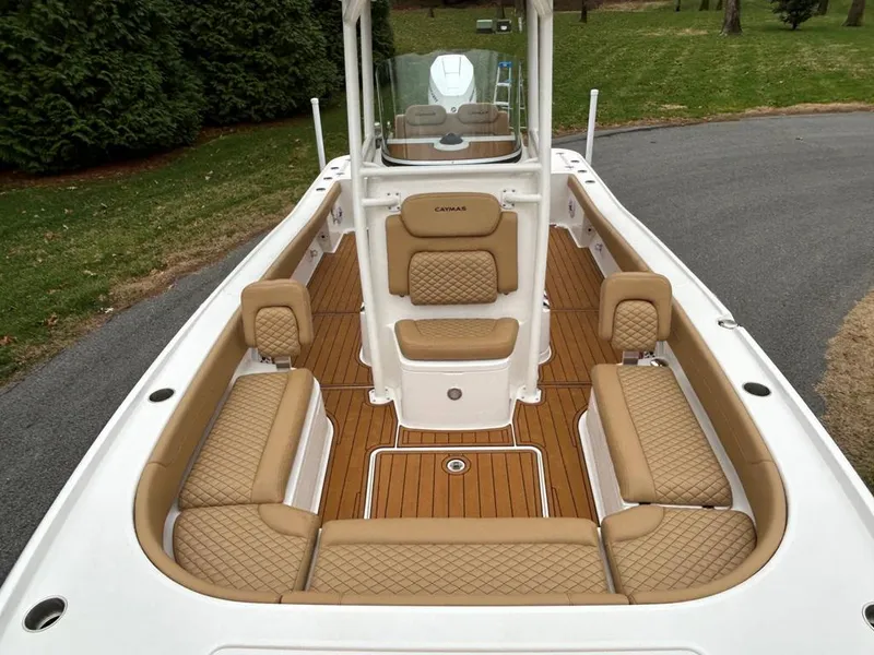 Slide: The Image of 2025 Caymas 26 HB boat with tan cushioned seating and teak flooring. - 43