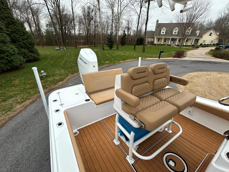 Slide: The Image of 2025 Caymas 26 HB boat with tan seating and teak flooring, parked in a driveway. - 46