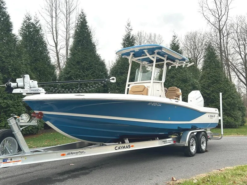 Slide: The Image of 2025 Caymas 26 HB boat on trailer, blue hull, parked outdoors. - 5