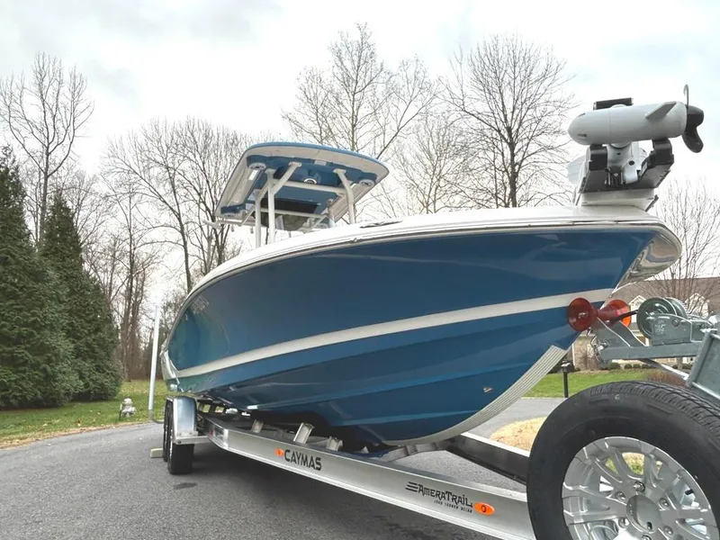 Slide: The Image of 2025 Caymas 26 HB boat on trailer, blue hull, parked outdoors. - 7