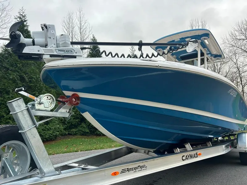 Slide: The Image of 2025 Caymas 26 HB boat on trailer, blue hull, parked outdoors. - 8