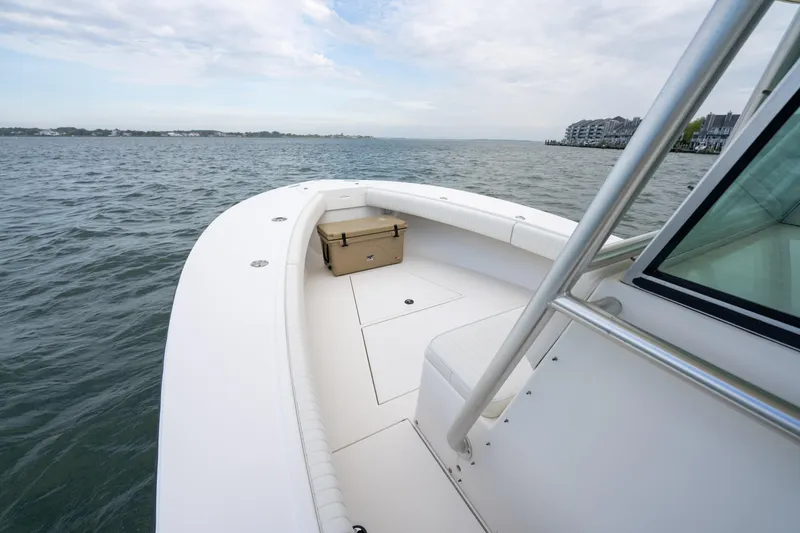 Slide: The Image of 2003 Regulator 32 Center Console boat on open water, featuring spacious deck and seating. - 15