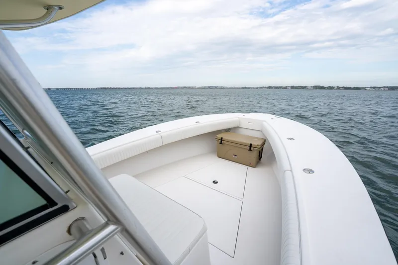Slide: The Image of 2003 Regulator 32 Center Console boat on open water, featuring spacious deck and seating. - 16