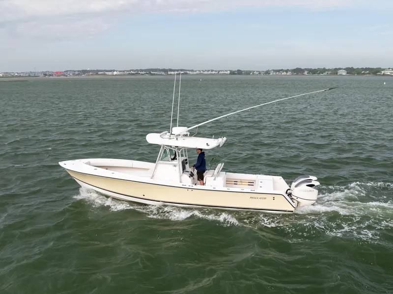 The Image of 2003 Regulator 32 Center Console boat cruising on open water. - 2