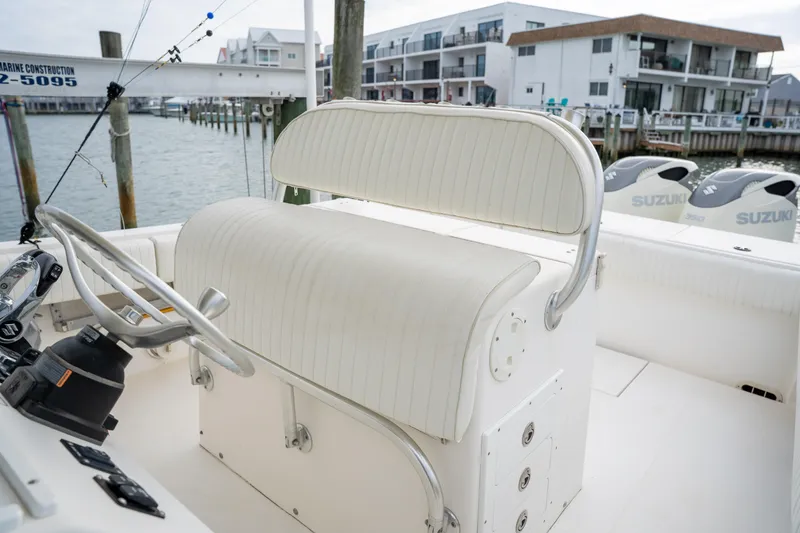 Slide: The Image of 2003 Regulator 32 Center Console boat with white seating and waterfront view. - 24