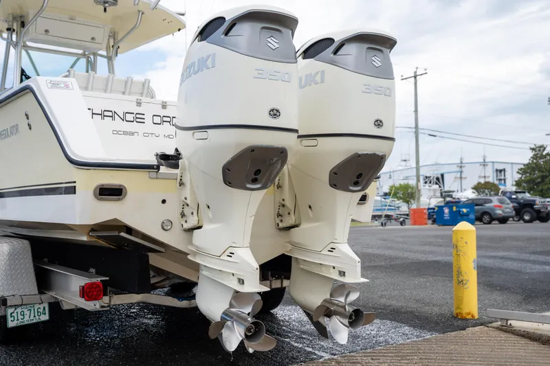 Slide: The Image of 2003 Regulator 32 Center Console with dual Suzuki outboard motors at a marina. - 8