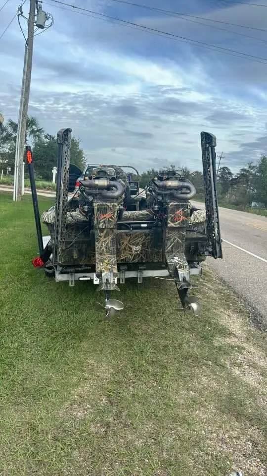 Slide: The Image of 2023 Go-Devil 2072 boat with dual engines parked on roadside grass. - 2