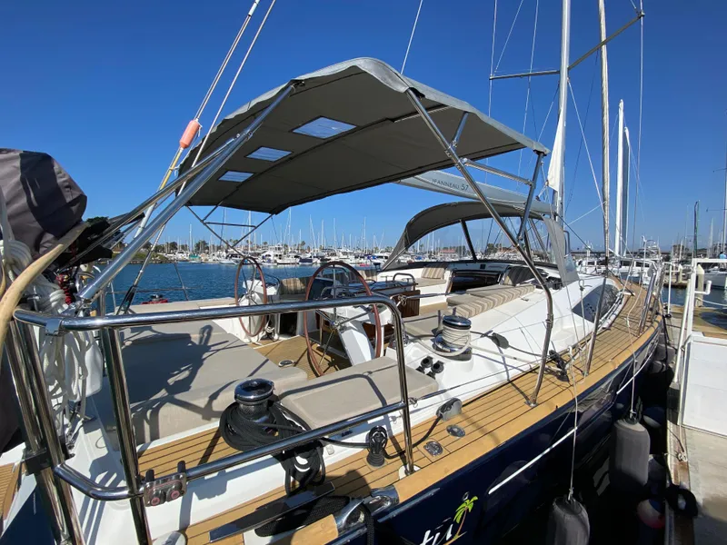 Slide: The Image of 2013 Jeanneau 57 sailboat docked at marina, featuring spacious deck and canopy. - 10