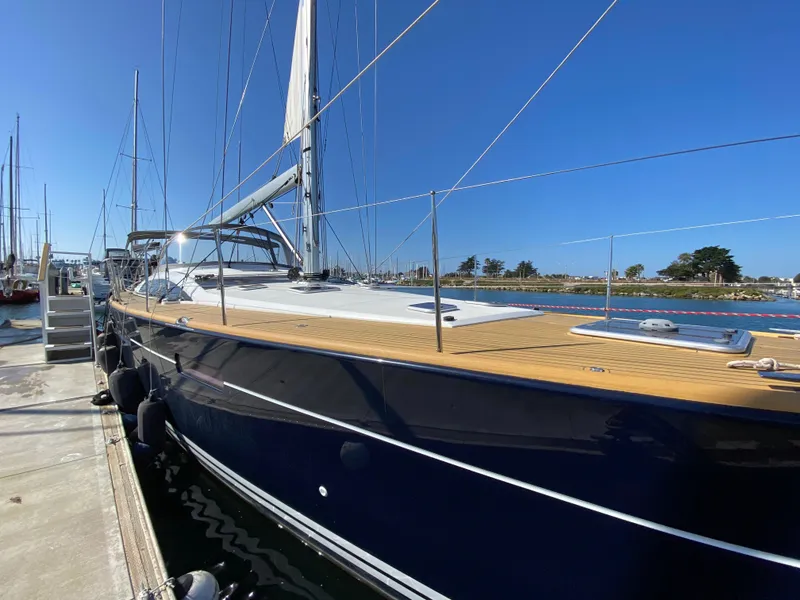 Slide: The Image of 2013 Jeanneau 57 yacht docked, featuring sleek design and spacious deck. - 16
