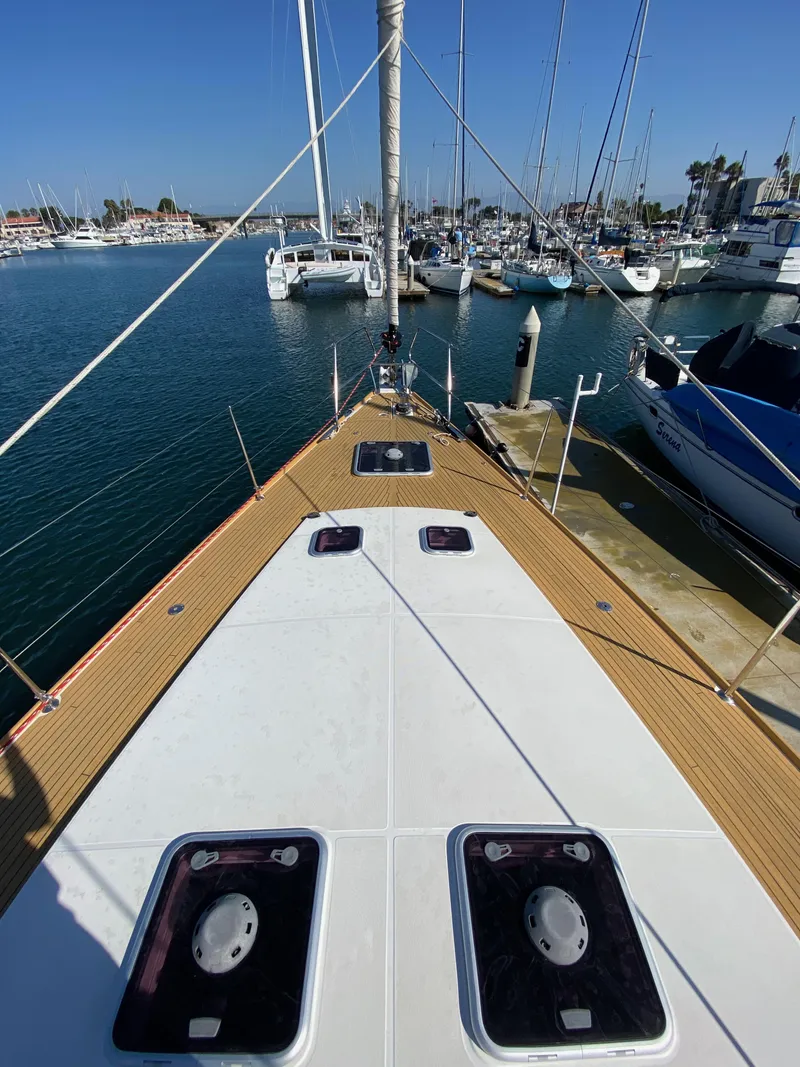 Slide: The Image of 2013 Jeanneau 57 yacht docked in marina, showcasing deck and mast. - 19