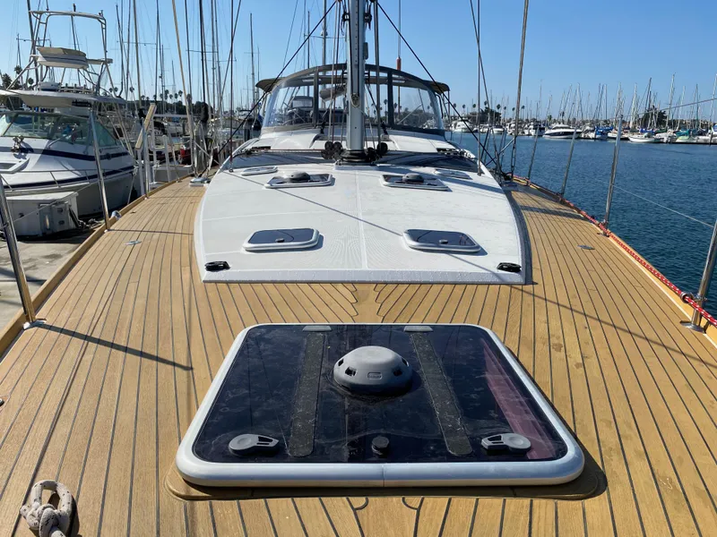 Slide: The Image of 2013 Jeanneau 57 sailboat deck with wooden finish, docked in a marina. - 27