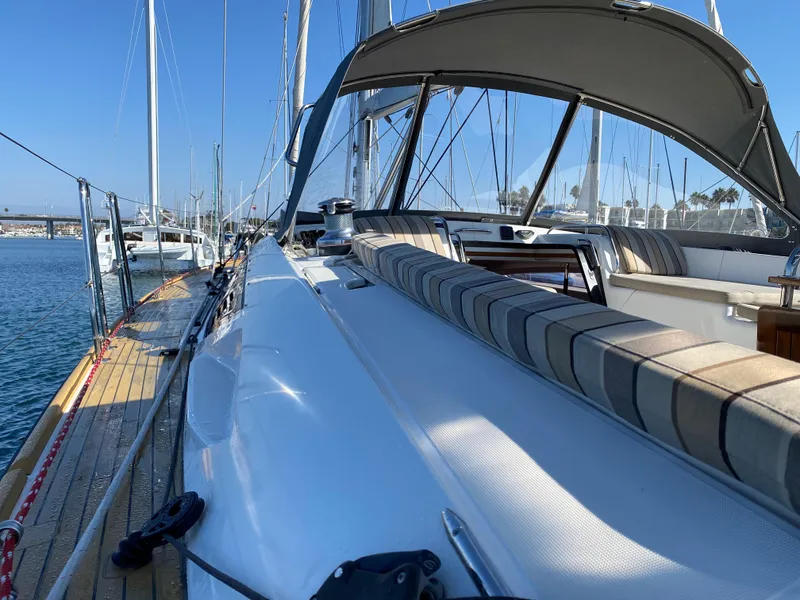 Slide: The Image of 2013 Jeanneau 57 sailboat with striped seating, docked in a sunny marina. - 46