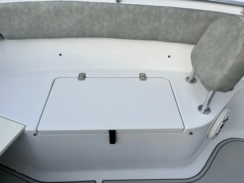 Slide: The Image of 2019 Sportsman Open 252 Center Console boat seating area with storage compartment. - 14