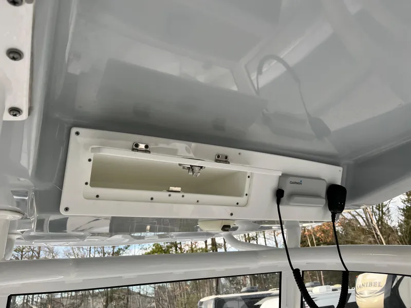 Slide: The Image of 2019 Sportsman Open 252 Center Console boat interior with storage compartment and radio. - 22