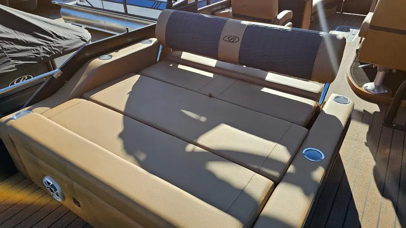 Slide: The Image of 2025 Bentley Pontoons Elite 253 Swingback with luxurious tan seating and cup holders. - 4