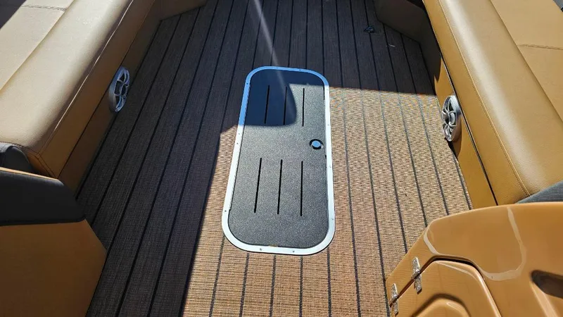 Slide: The Image of 2025 Bentley Pontoons Elite 253 Swingback interior with tan seating and textured flooring. - 6