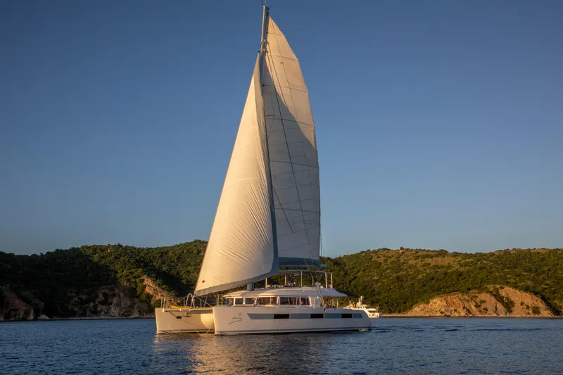 The Image of Lagoon 620 catamaran sailing on calm waters at sunset, 2014 model. - 0