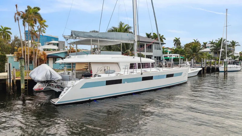 Slide: The Image of 2014 Lagoon 620 catamaran docked in a tropical marina setting. - 10