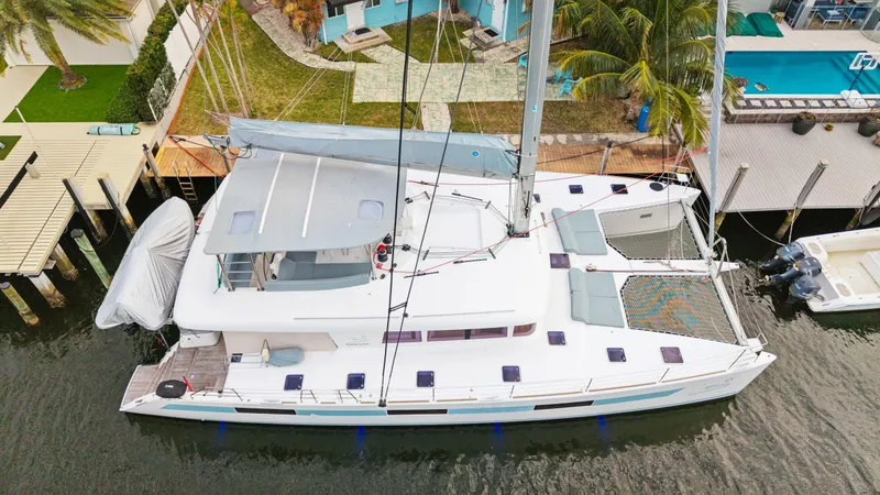 Slide: The Image of 2014 Lagoon 620 catamaran docked near waterfront property, aerial view. - 12