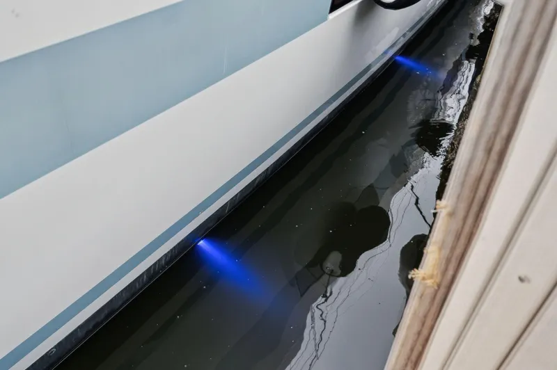 Slide: The Image of Lagoon 620 yacht with underwater blue lights, 2014 model, docked in calm water. - 19