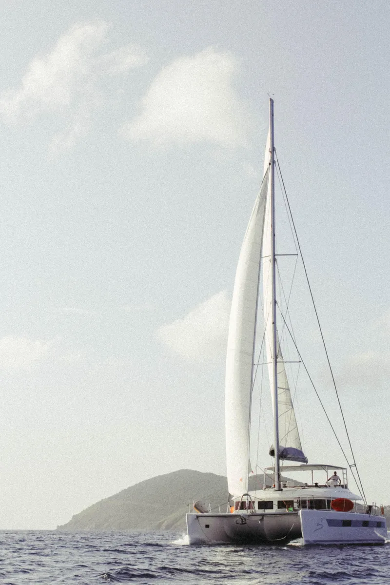 Slide: The Image of Lagoon 620 catamaran sailing near an island, 2014 model. - 2