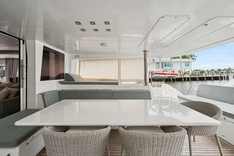 Slide: The Image of Lagoon 620 yacht interior, 2014 model, featuring a sleek dining area with wicker chairs. - 32