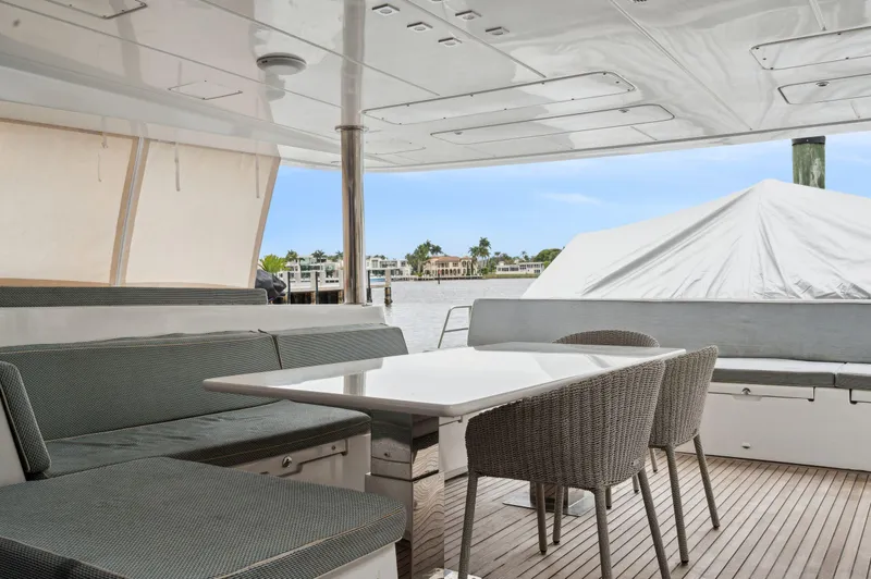 Slide: The Image of Lagoon 620 yacht 2014, spacious deck with seating and table, waterfront view. - 34