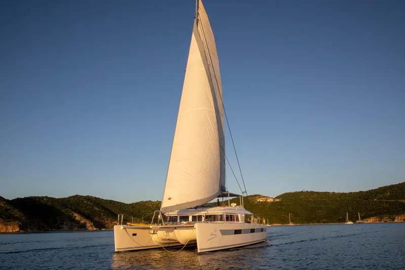 Slide: The Image of 2014 Lagoon 620 catamaran sailing on calm waters at sunset. - 4