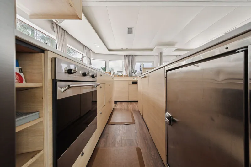 Slide: The Image of Interior of 2014 Lagoon 620 yacht kitchen with modern appliances and wood finish. - 45