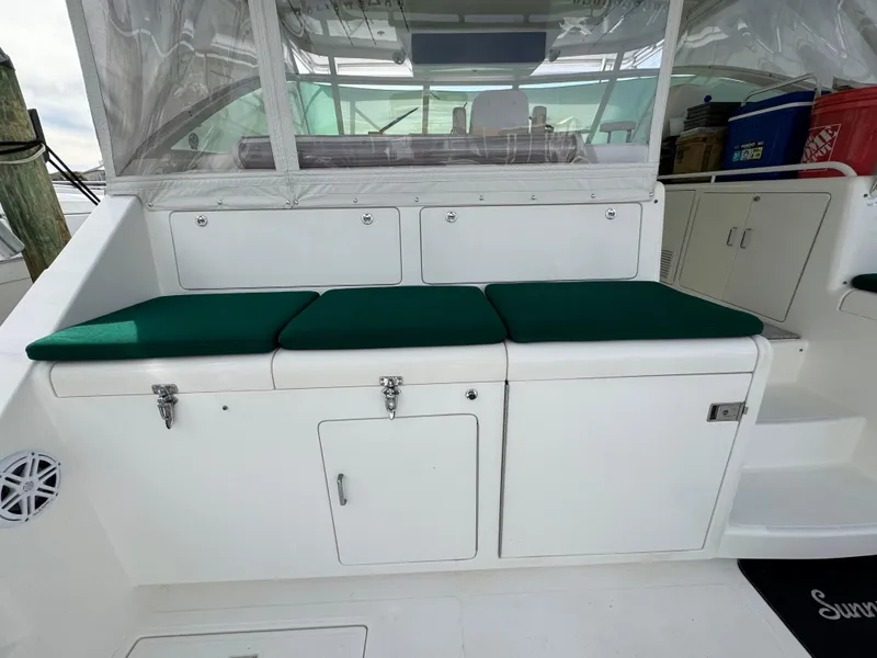 Slide: The Image of 1999 Cabo 45 Express boat interior with green cushioned seating and storage compartments. - 11