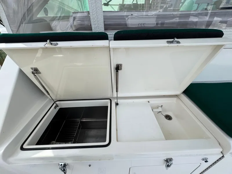 Slide: The Image of 1999 Cabo 45 Express boat sink and storage area with open lids. - 12