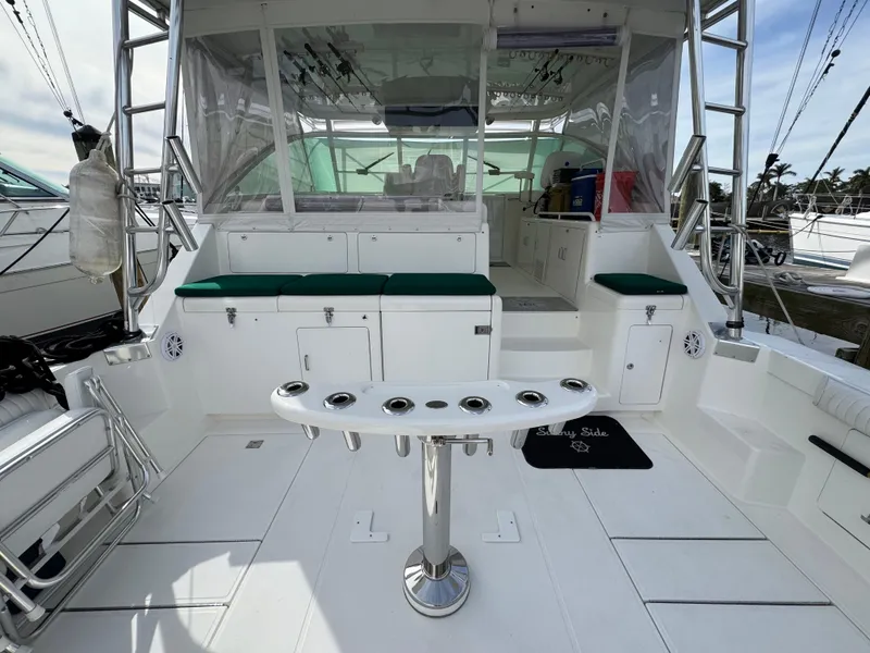 Slide: The Image of 1999 Cabo 45 Express yacht cockpit with fishing rod holders and seating. - 13
