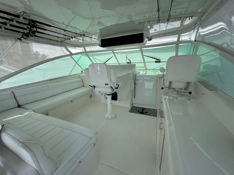 Slide: The Image of 1999 Cabo 45 Express yacht interior with white seating and helm station. - 14
